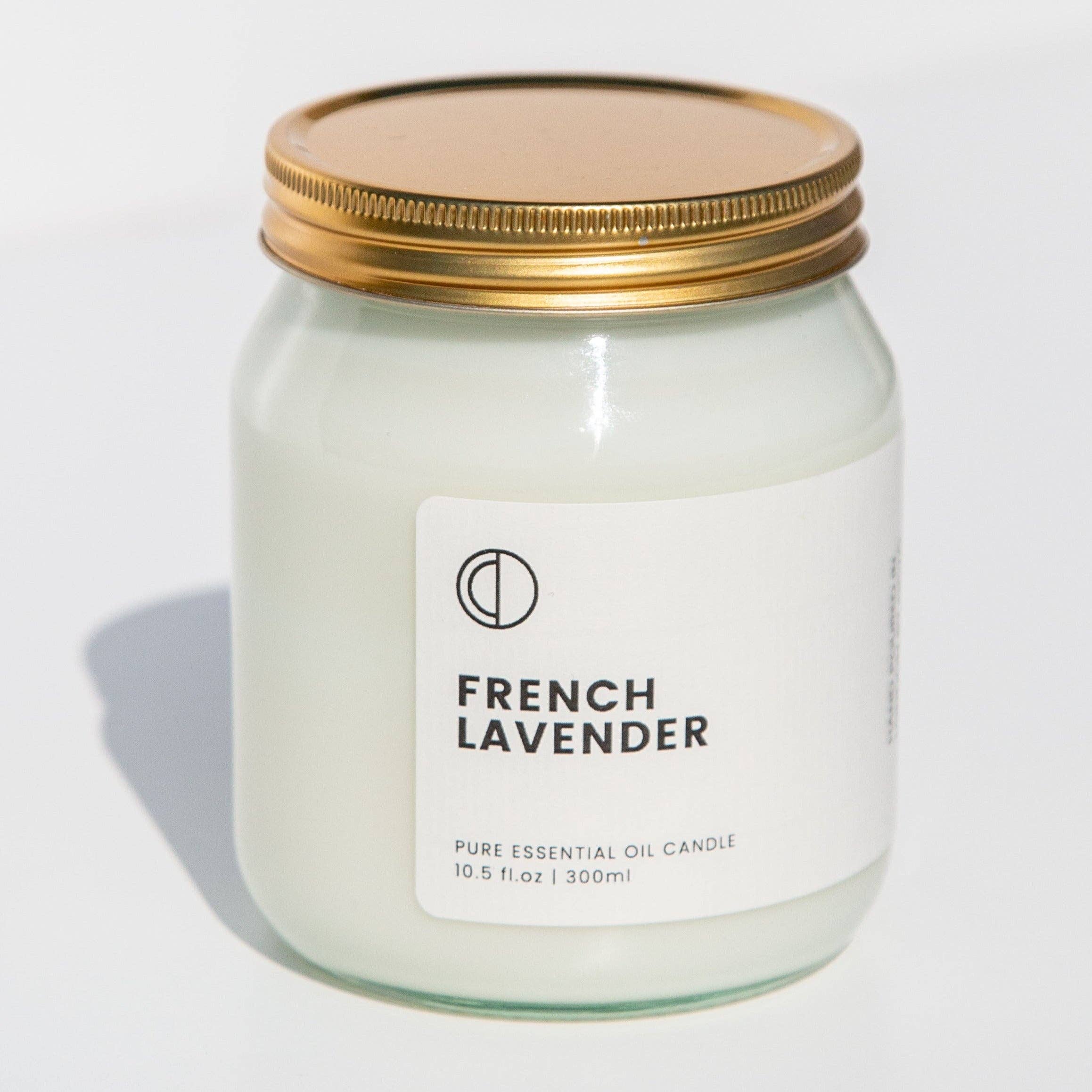 A white candle labeled 'FRENCH LAVENDER' with a gold lid, indicating it is a pure essential oil candle in a 300ml size.
